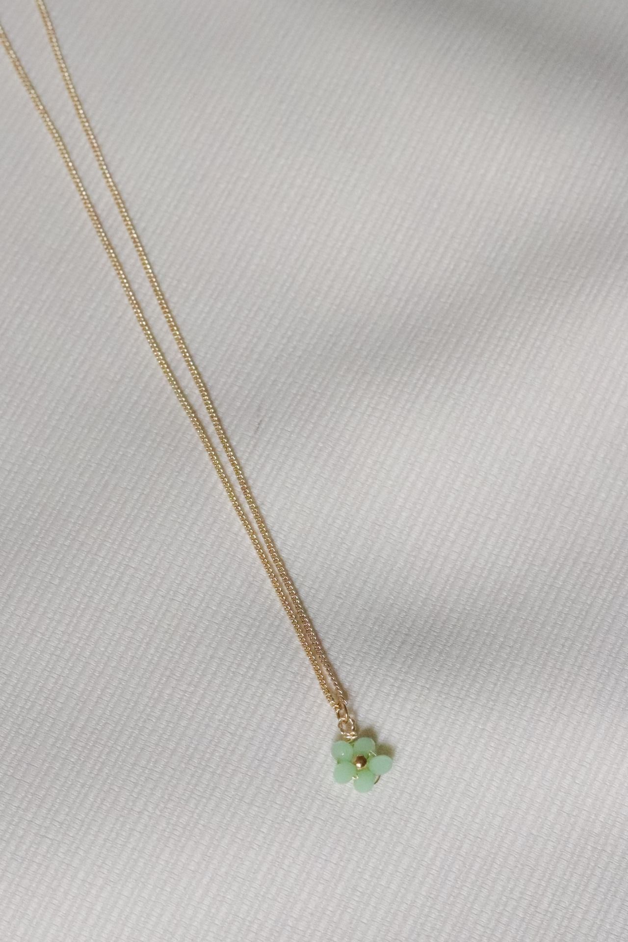 Collar Dalia, flor verde y lila. Material: Acero. El largo de la cadena es de 45 cm, el grosor de la cadena 1mm y el dije mide 1.3cm de alto. 
